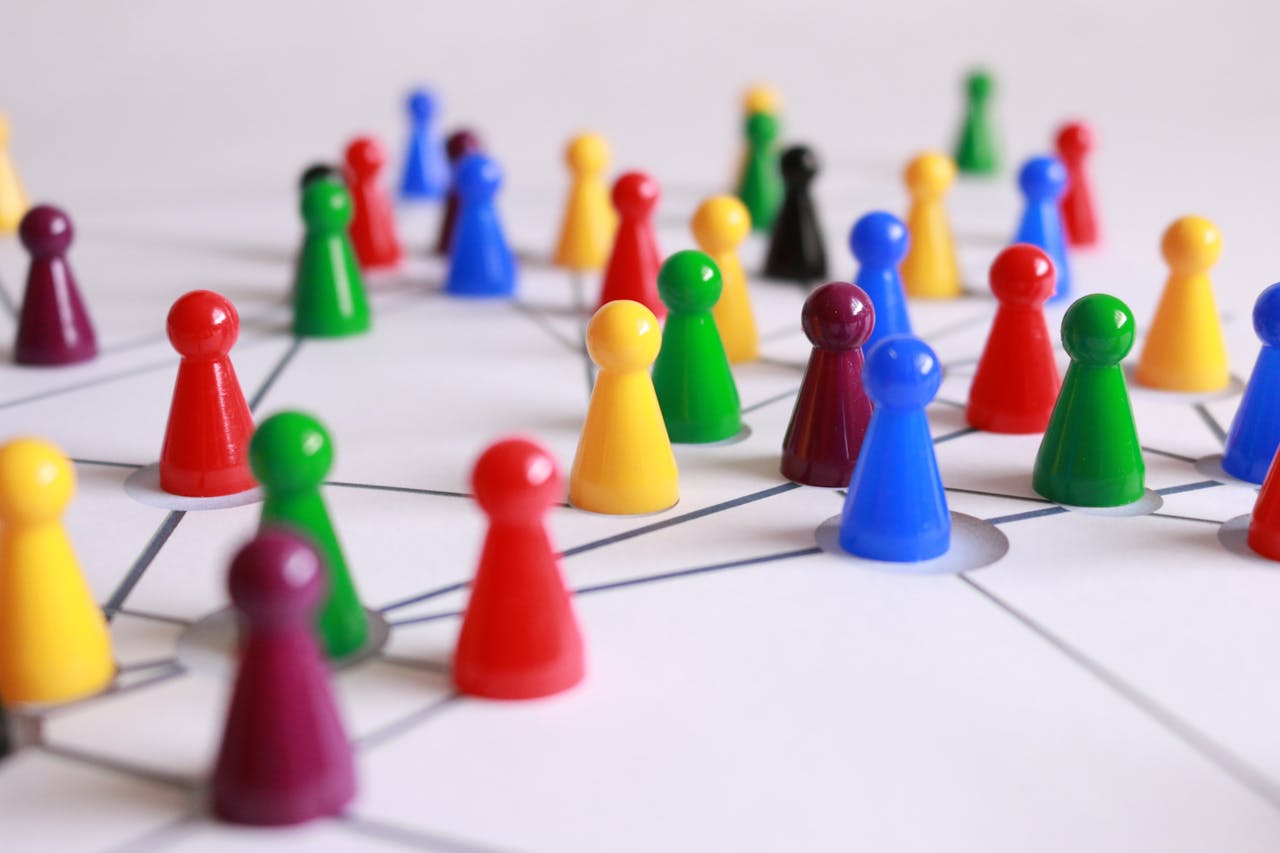 Home A strategic arrangement of colorful pawns connected on a game board, symbolizing networking and teamwork.